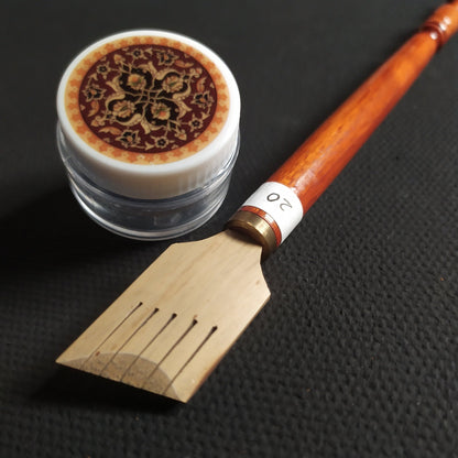 student writing Arabic calligraphy using kit