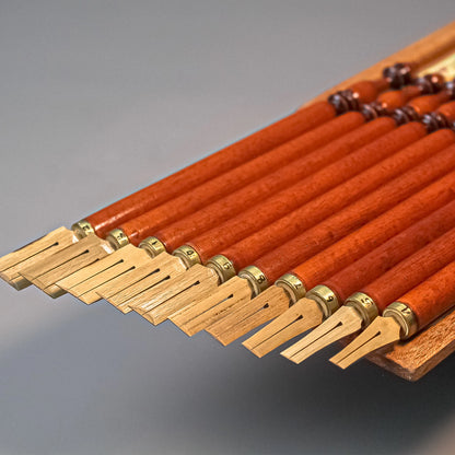 Hand holding bamboo qalam for calligraphy